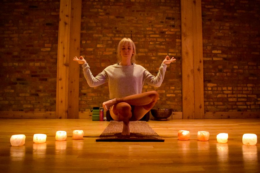 Seated cross-legged with the hands open at the shoulders, salt lamps glowing