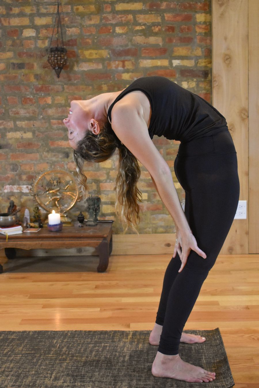 A standing backbend, the arms reaching down toward the floor behind