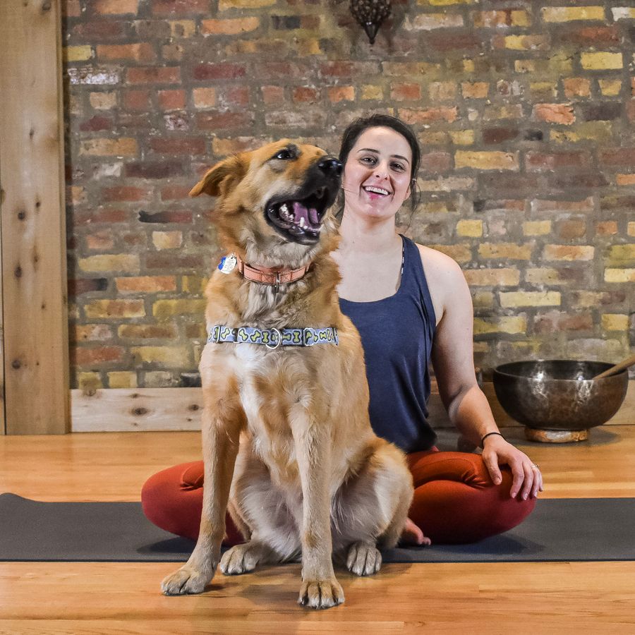 Sitting cross-legged and laughing beside a dog