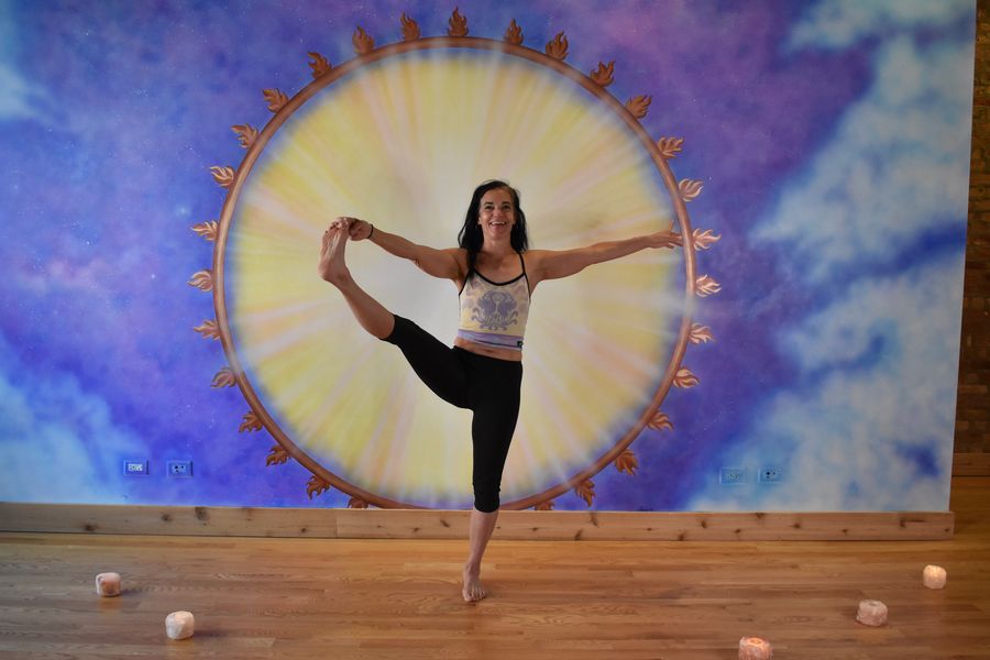 A standing balance holding one foot out to the side, at the sun mural