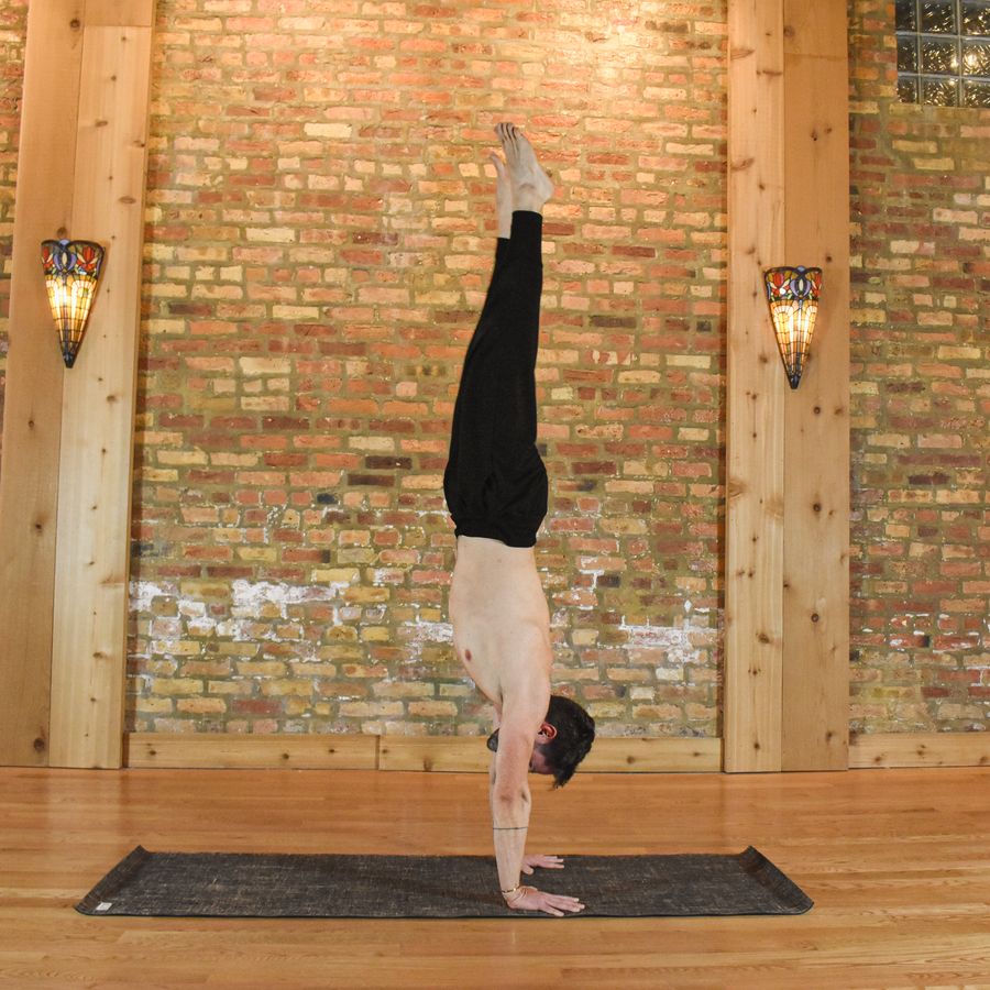 A straight handstand between two wall lamps