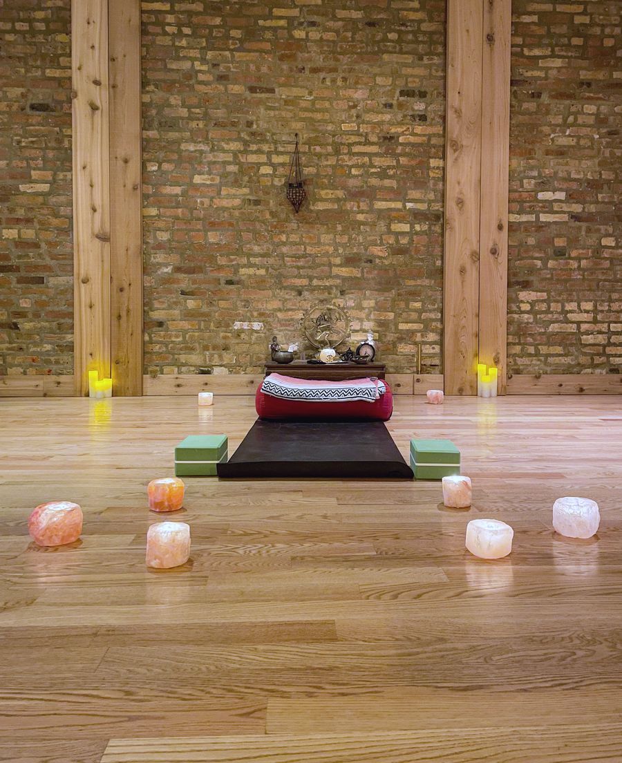 Candles and salt lamps set out on the wood floor before an evening class