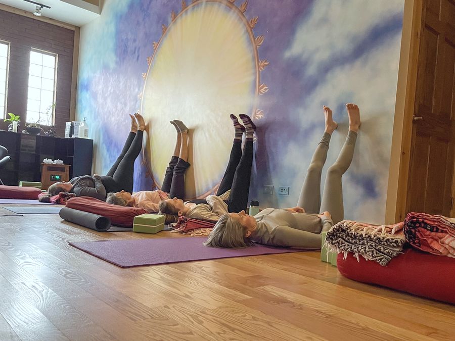A class resting with legs up the wall under the painted sun mural