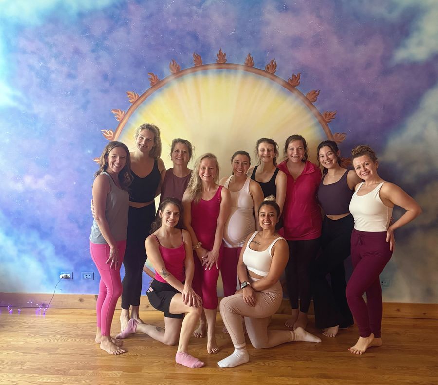 A bachelorette group smiling together in front of the sun mural