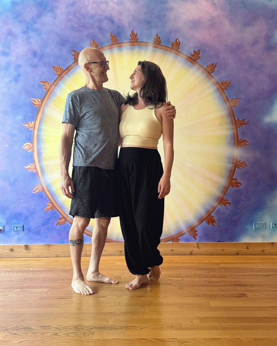 Rich and Nora looking at each other in front of the painted sun mural